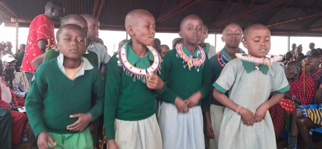 Schulkinder in Uniform singen bei der Begrüßung in Loolepo